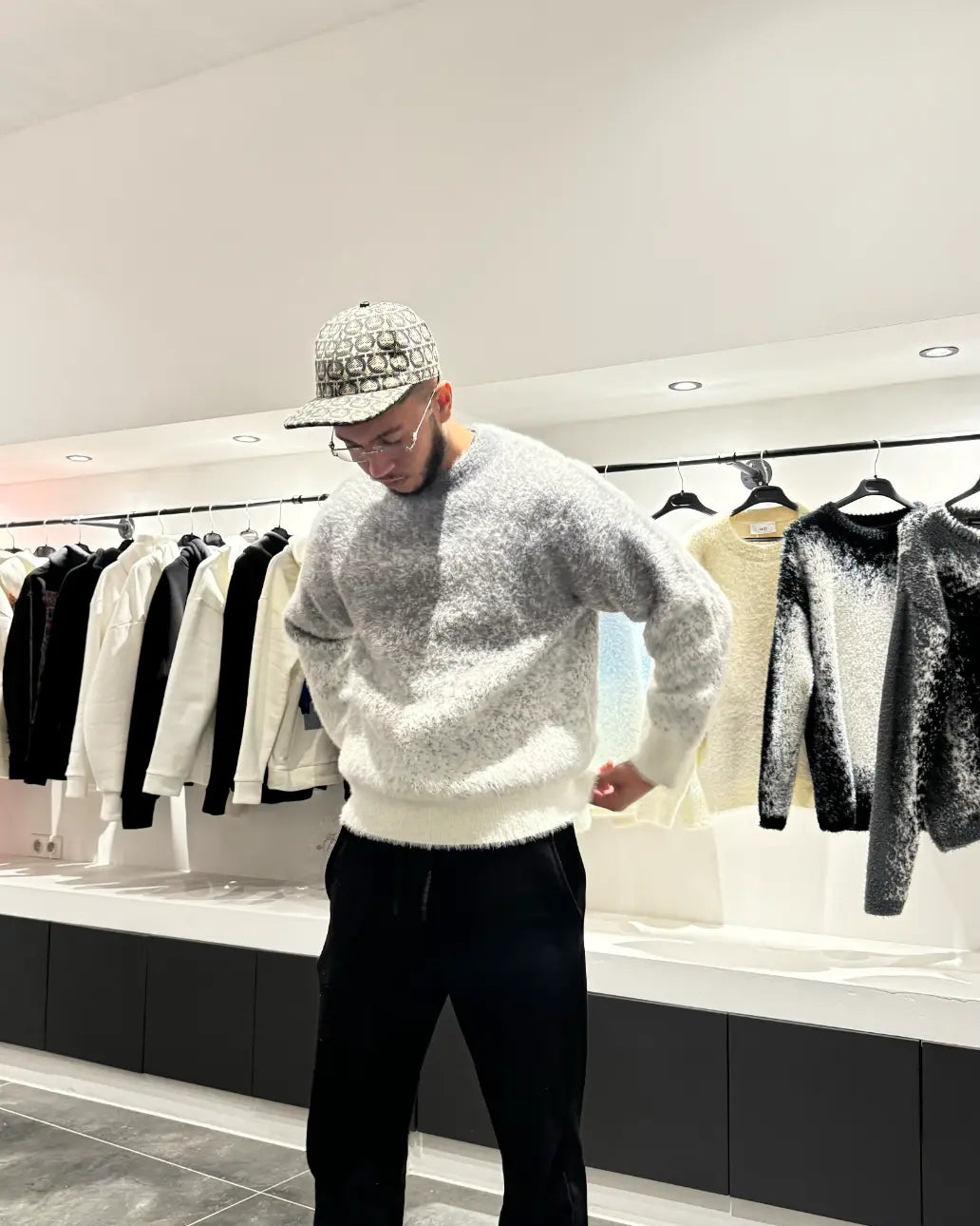 Silhouette nette du modèle debout présentant le pull en maille épaisse gris chiné.