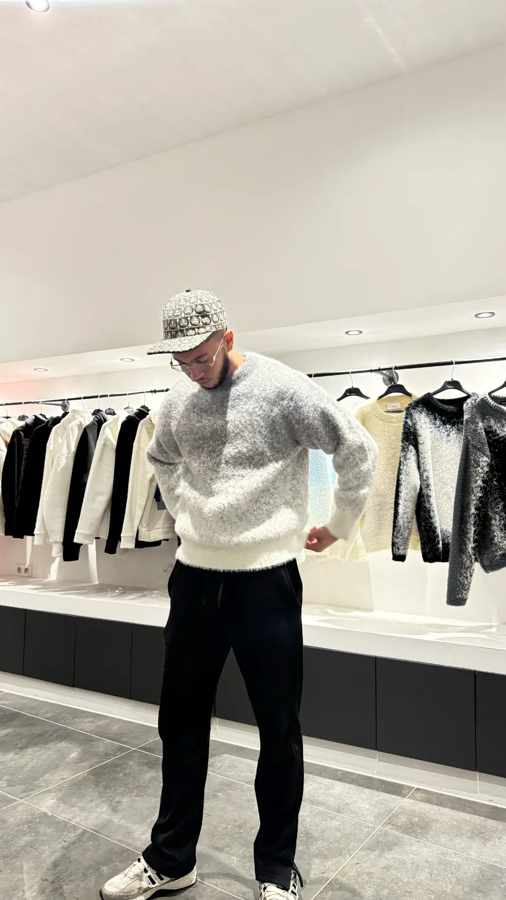 Silhouette nette du modèle debout présentant le pull en maille épaisse gris chiné.