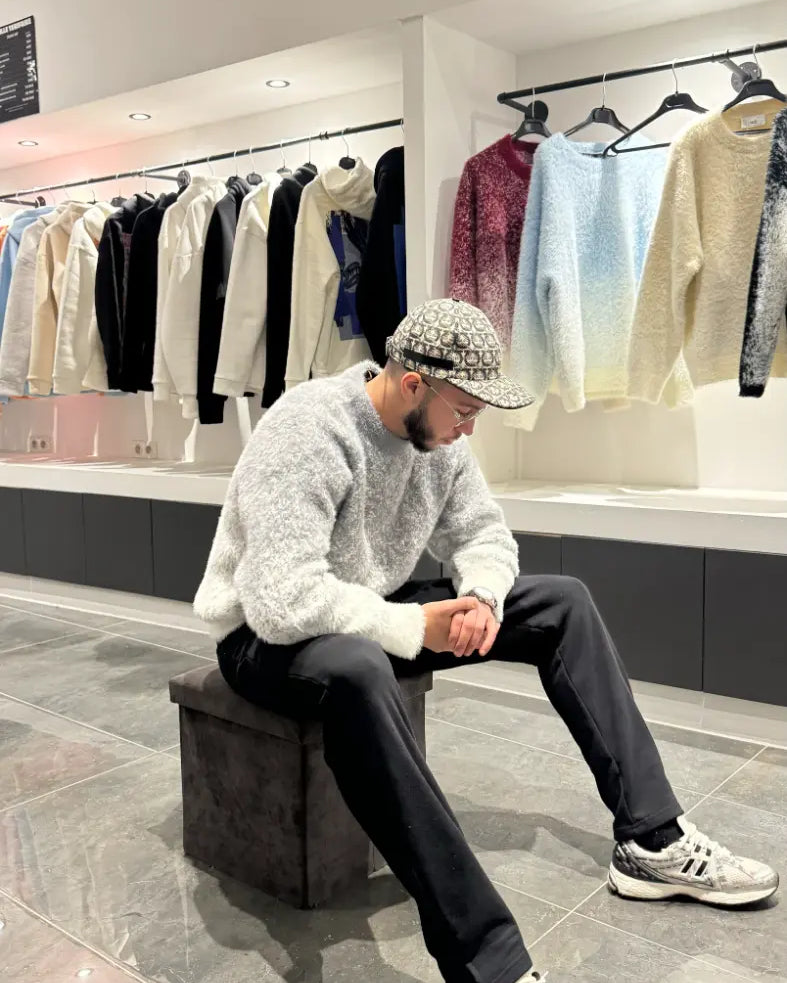 Pose assise mettant en valeur le confort thermique et la texture riche du pull gris.