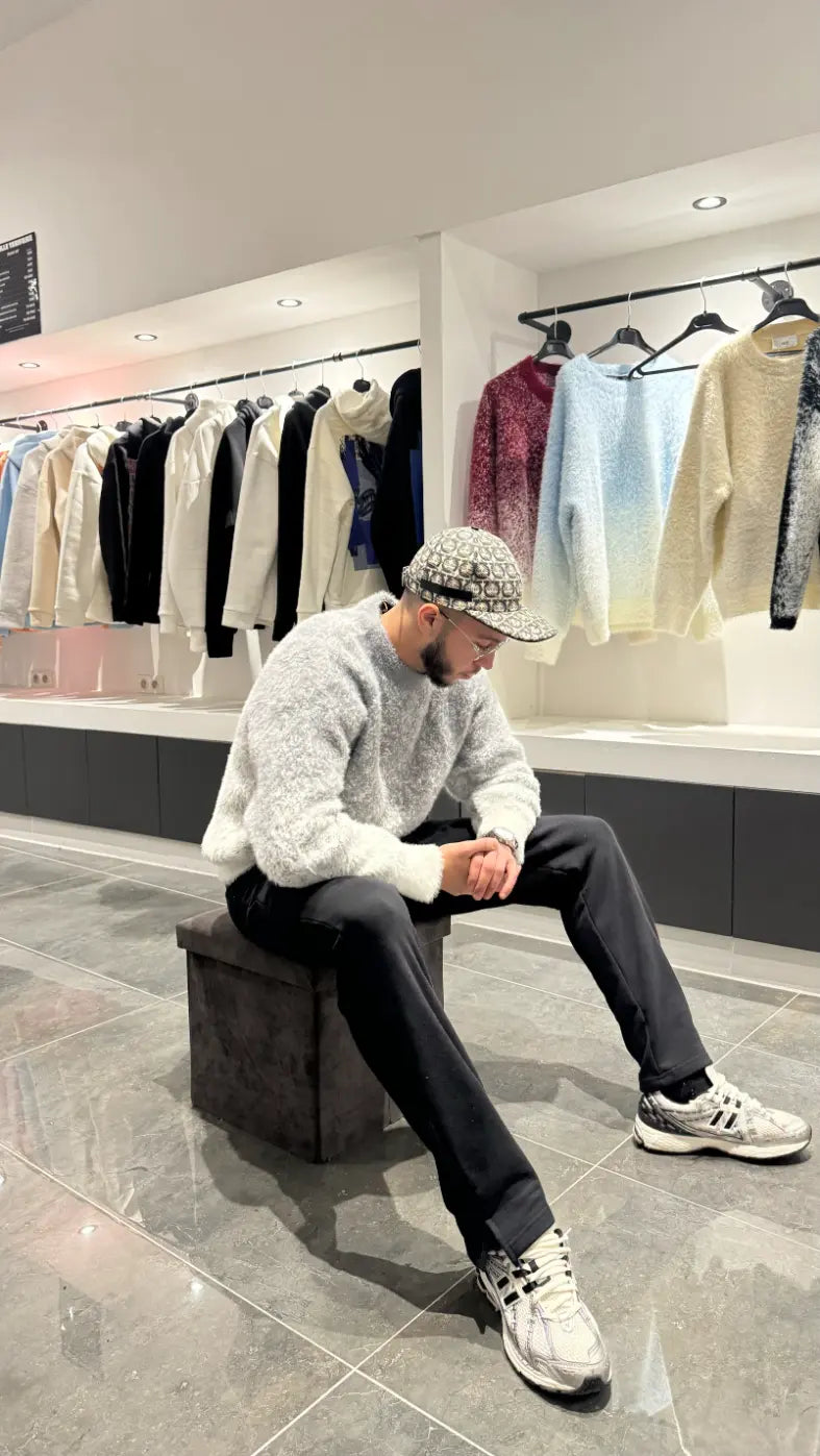 Pose assise mettant en valeur le confort thermique et la texture riche du pull gris.
