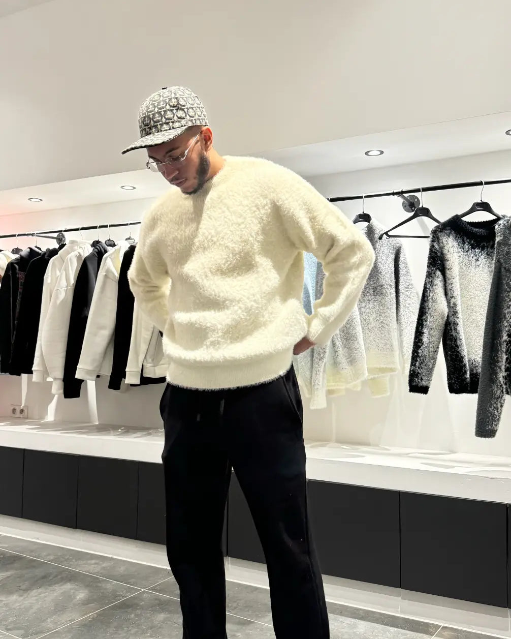 Silhouette élégante du modèle debout avec le pull premium beige au tombé lourd caractéristique.