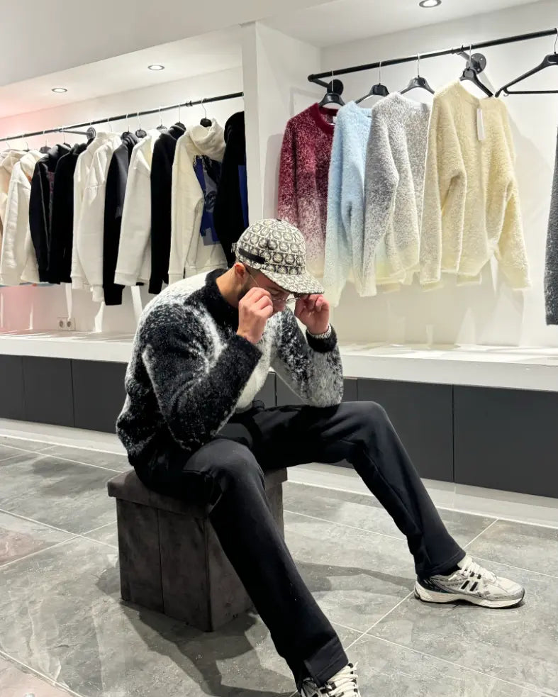 Focus sur la finition premium et le relief unique du tricot blanc et noir assis.