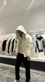 Silhouette complète présentant la doudoune blanche texturée avec la capuche pour un look hivernal total.