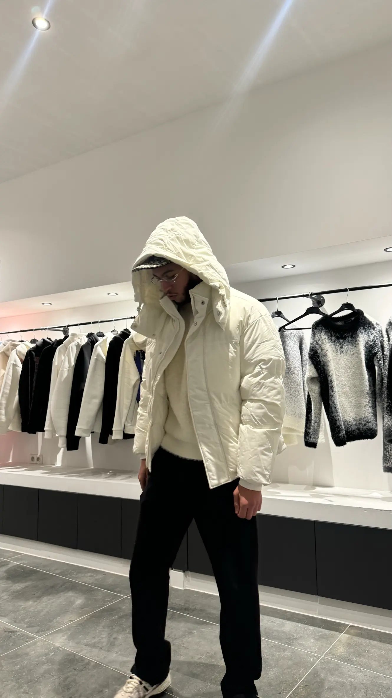 Silhouette complète présentant la doudoune blanche texturée avec la capuche pour un look hivernal total.