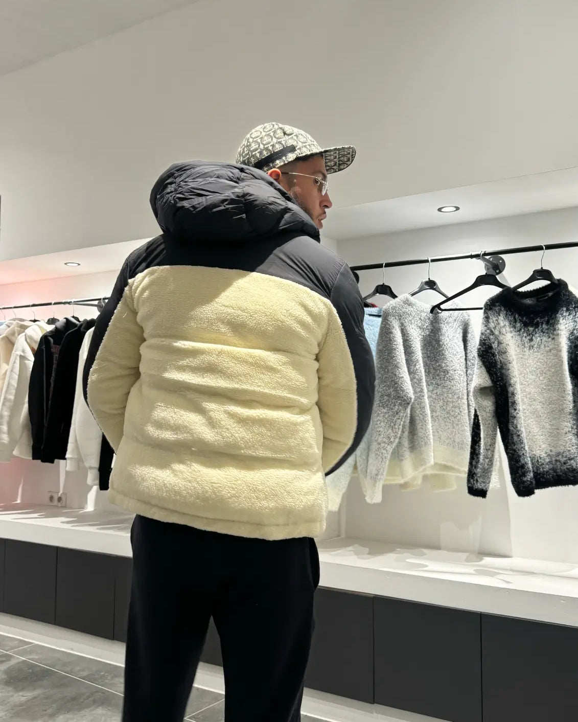 Vue de face soulignant le contraste entre les empiècements noirs et le corps beige en sherpa chaud.