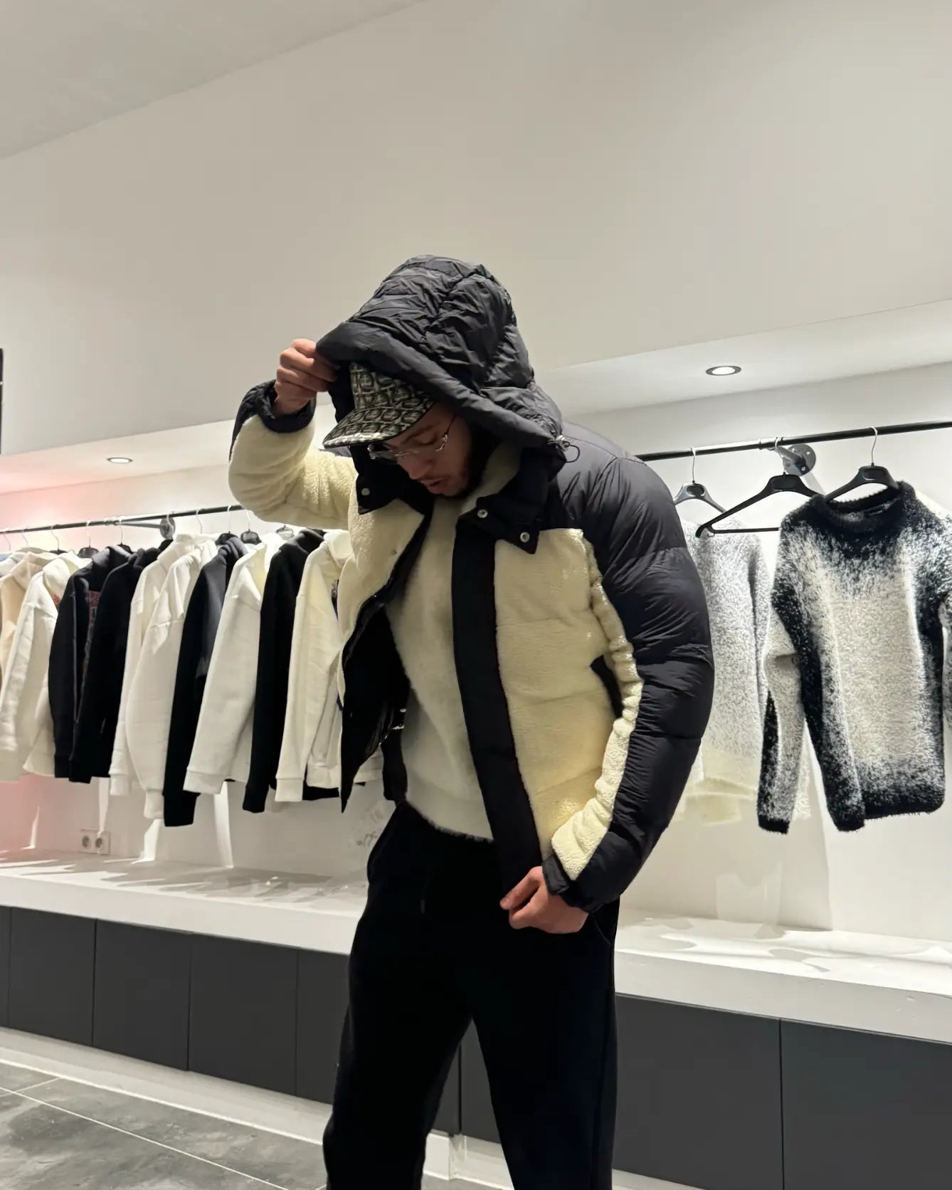 Silhouette complète montrant la doudoune bicolore beige et noir et l'aspect texturé de la matière sherpa.