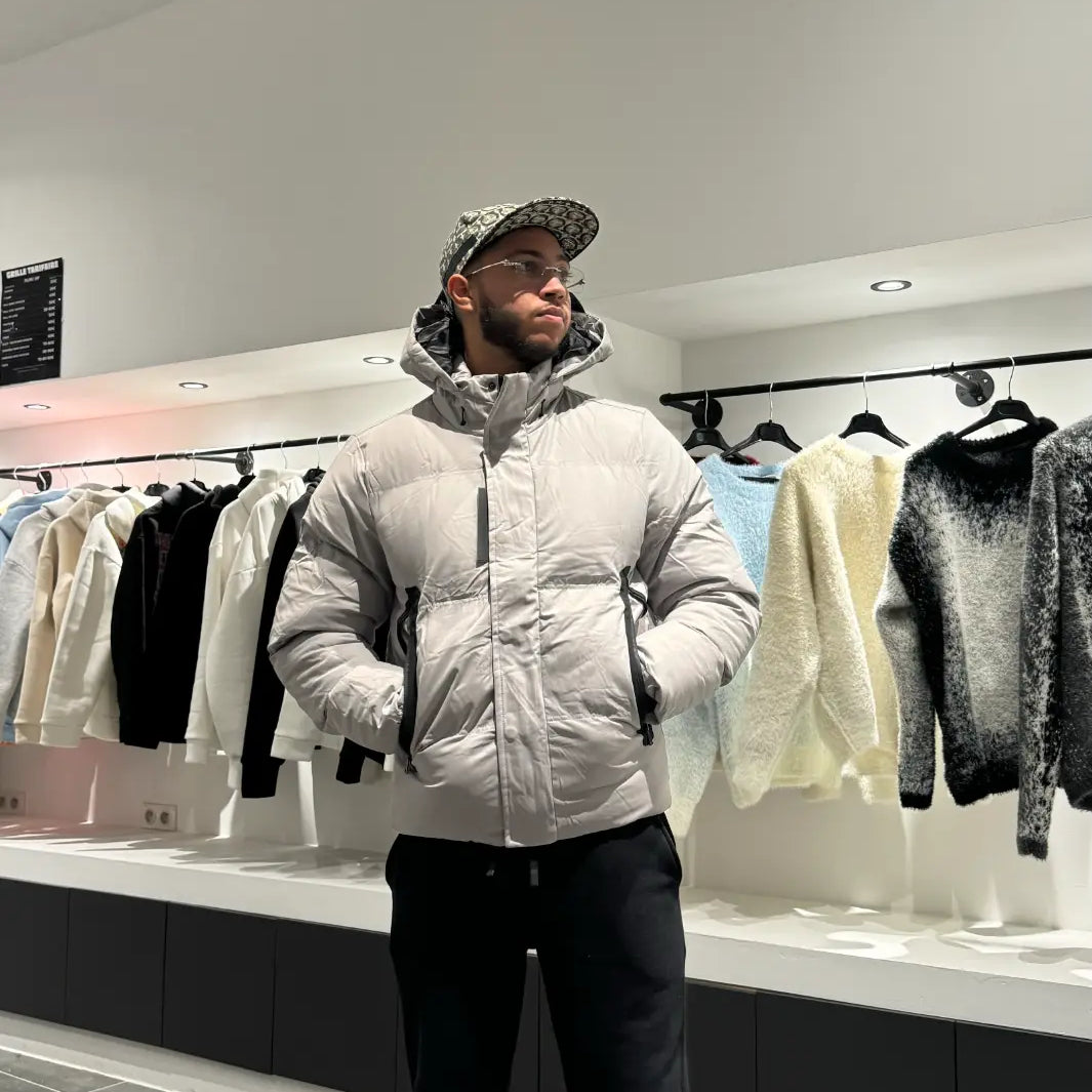 Silhouette complète montrant la doudoune grise monochrome avec sa capuche pour un look d'hiver épuré.