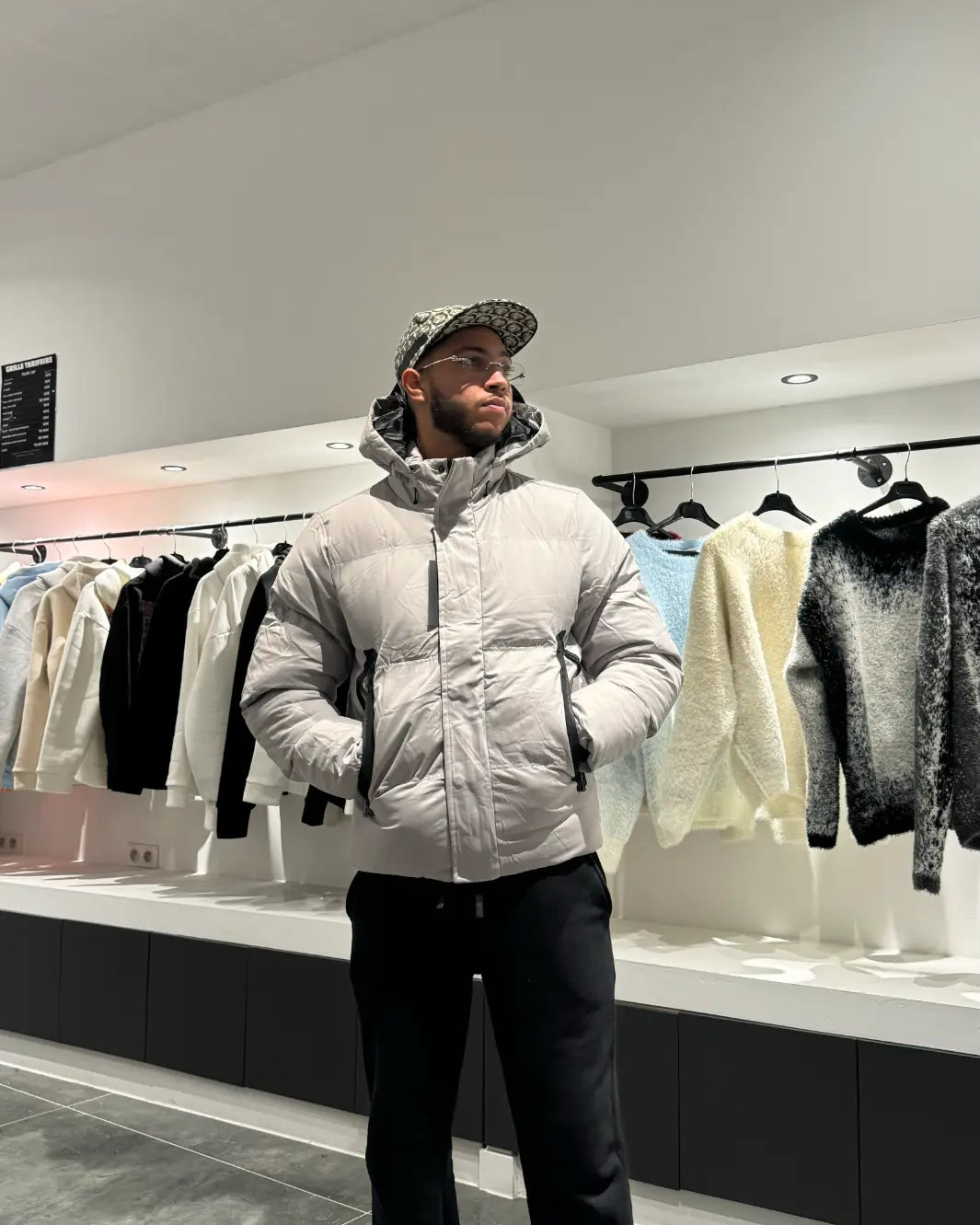 Silhouette complète montrant la doudoune grise monochrome avec sa capuche pour un look d'hiver épuré.