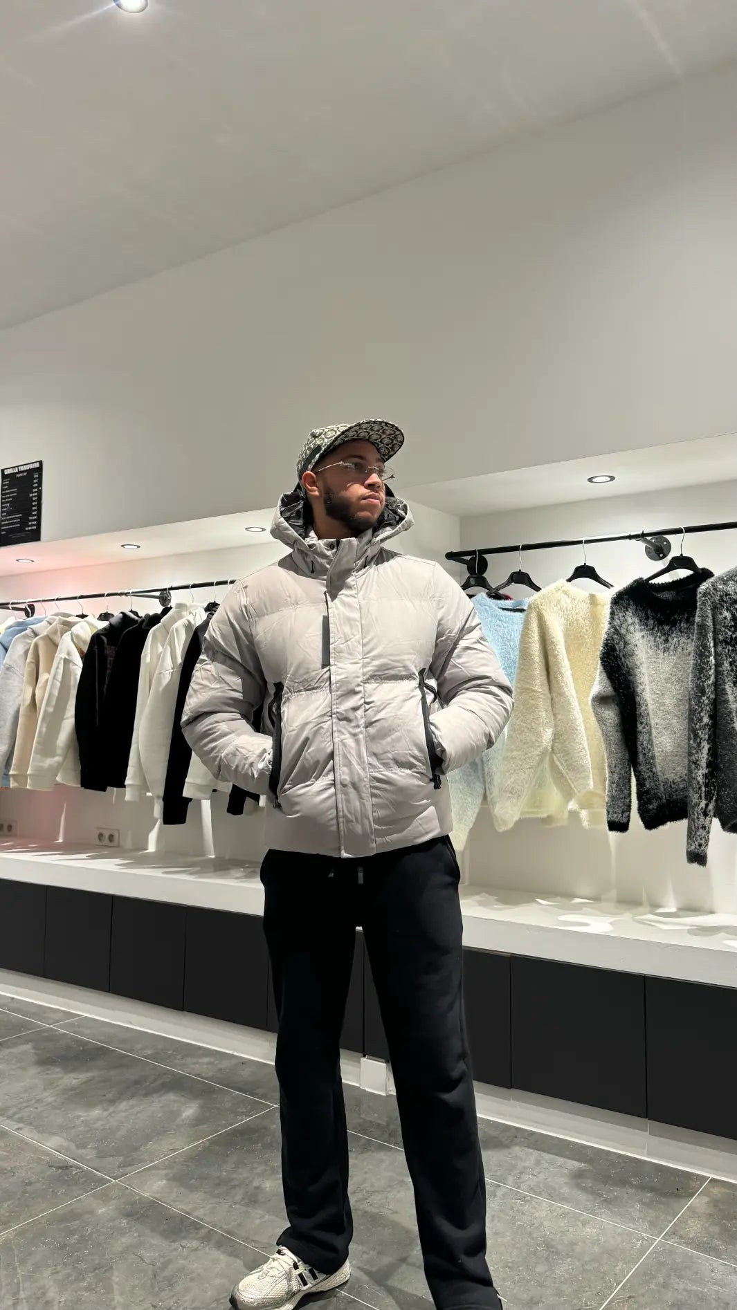 Silhouette complète montrant la doudoune grise monochrome avec sa capuche pour un look d'hiver épuré.