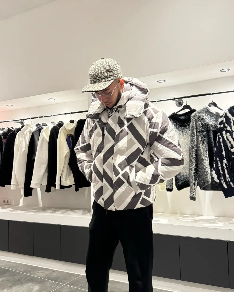 Silhouette complète présentant la doudoune à motif abstrait gris et blanc avec capuche pour un style outdoor moderne.