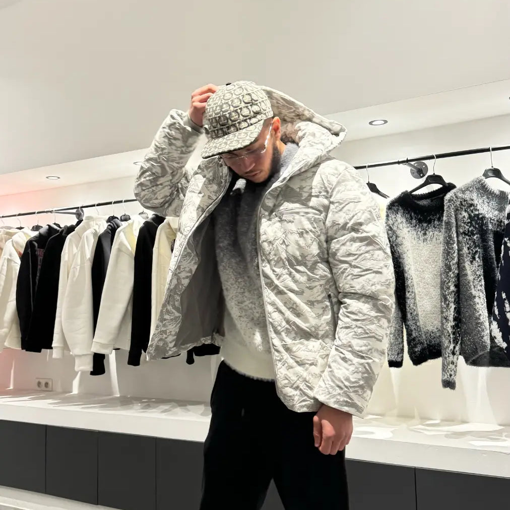 Silhouette complète montrant la doudoune au motif marbré gris et blanc avec capuche, pour un look urbain et sophistiqué.