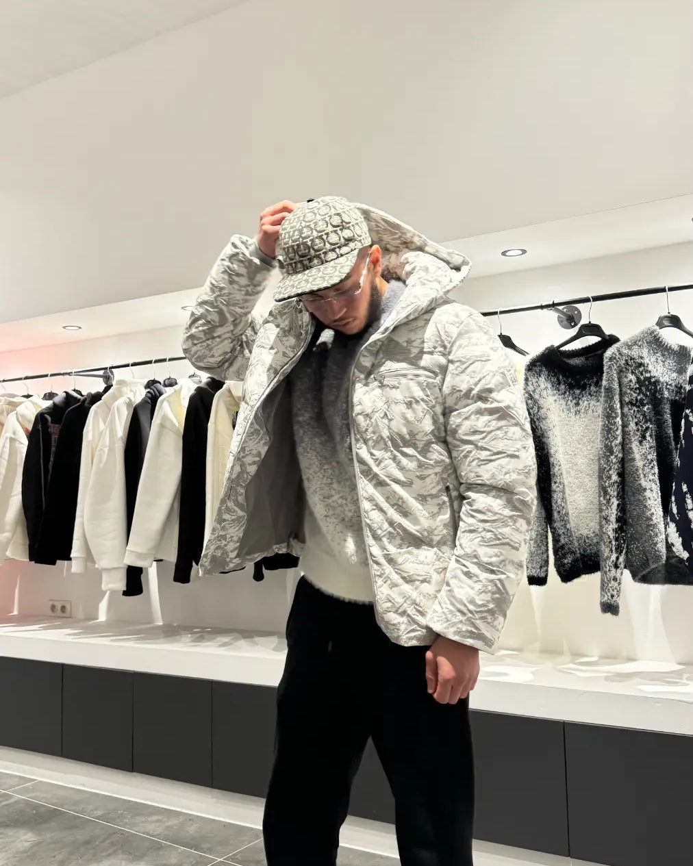 Silhouette complète montrant la doudoune au motif marbré gris et blanc avec capuche, pour un look urbain et sophistiqué.