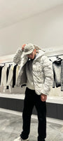 Silhouette complète montrant la doudoune au motif marbré gris et blanc avec capuche, pour un look urbain et sophistiqué.