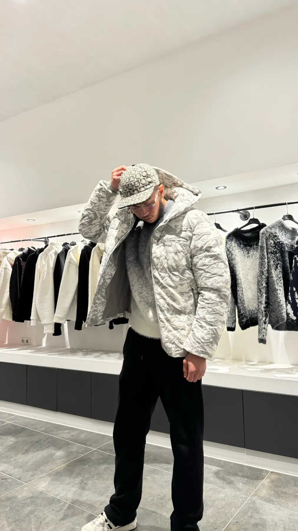 Silhouette complète montrant la doudoune au motif marbré gris et blanc avec capuche, pour un look urbain et sophistiqué.