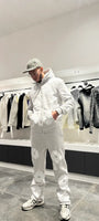 Silhouette complète présentant l'ensemble gris coordonné avec les broderies fleurs blanches bien visibles sur le hoodie et le jogging.