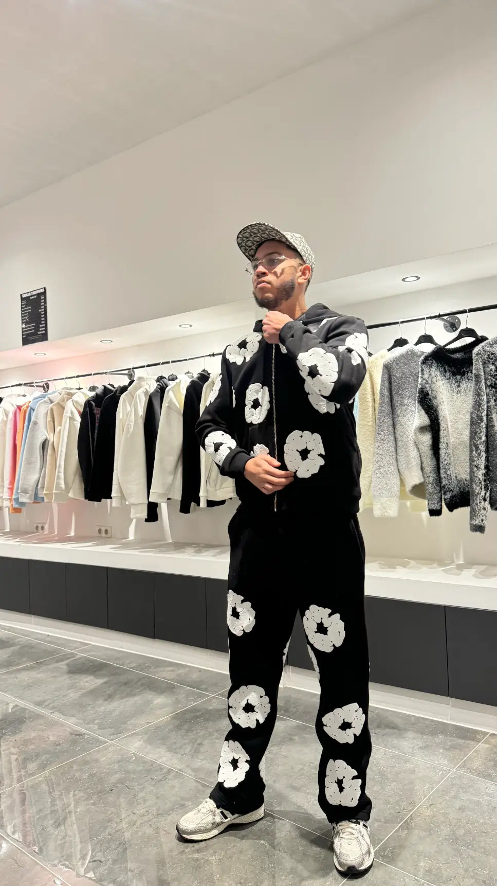 Vue de face de l'ensemble noir montrant le hoodie zippé fermé et la coupe ajustée du jogging.