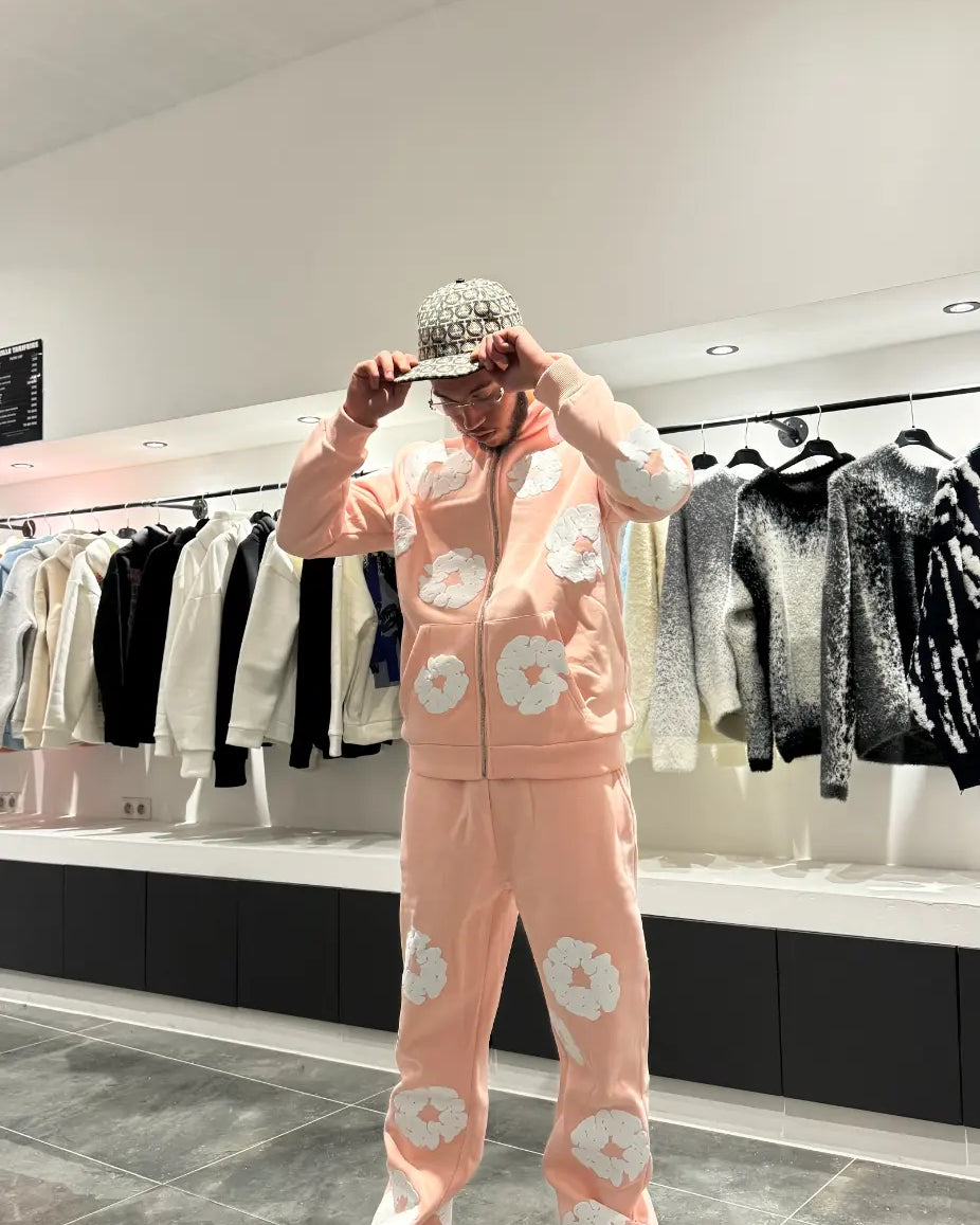 Vue de face montrant la coupe ajustée du jogging rose et le style moderne du hoodie zippé.