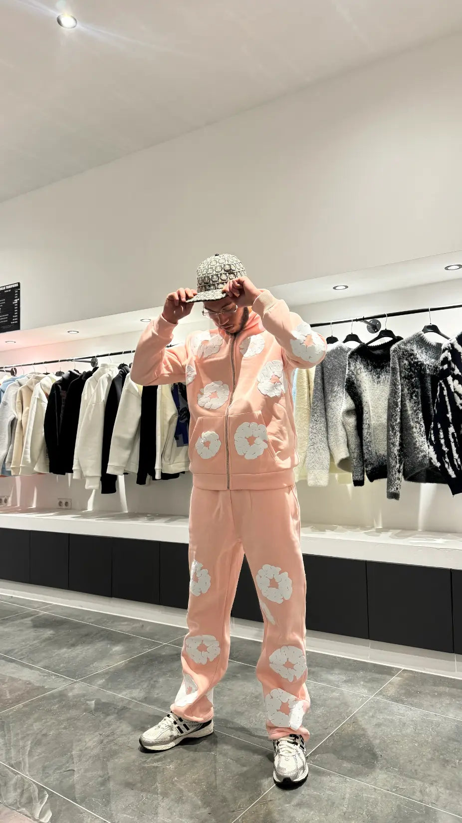 Vue de face montrant la coupe ajustée du jogging rose et le style moderne du hoodie zippé.