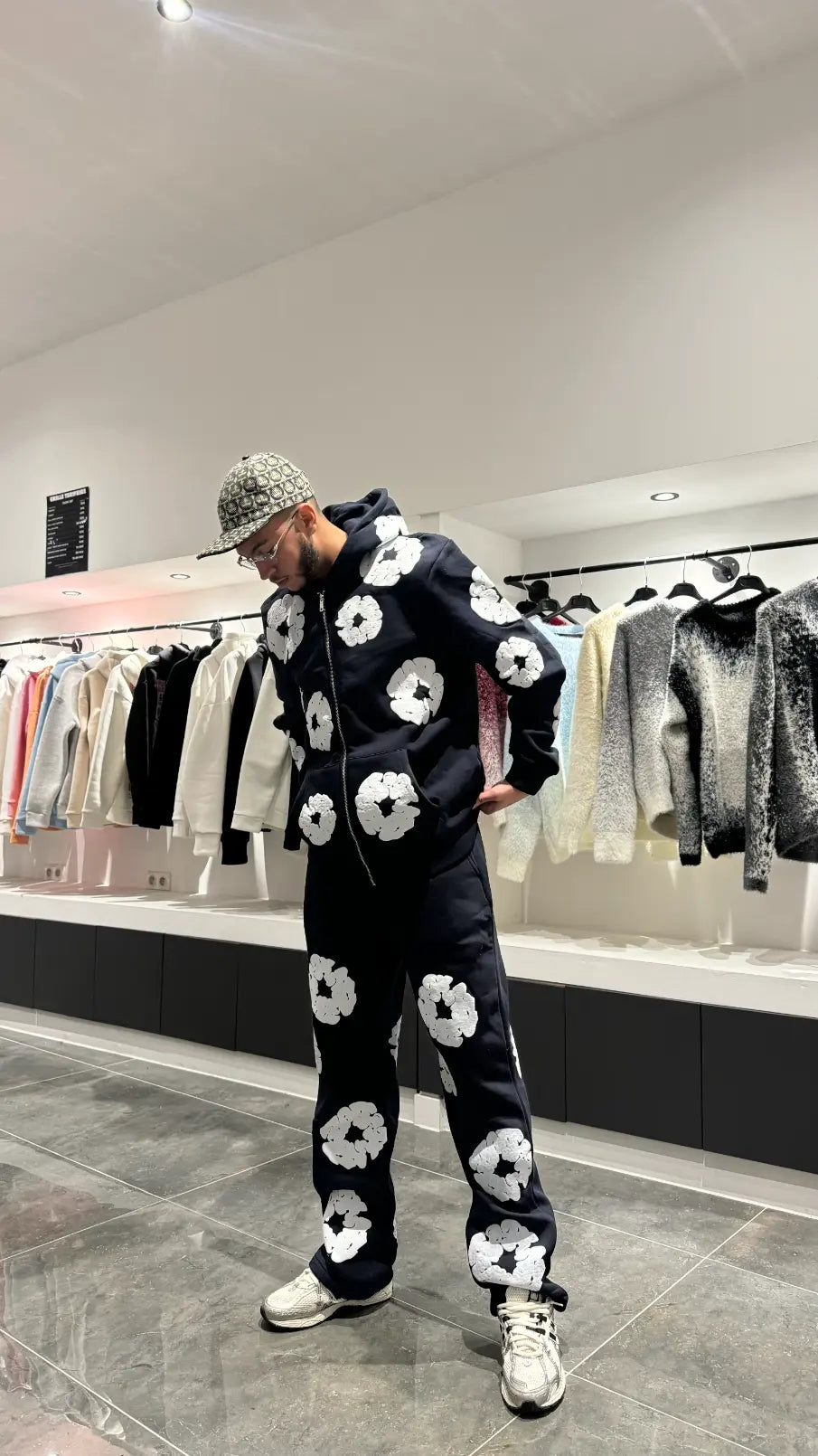 Modèle debout portant l'ensemble bleu foncé coordonné avec les motifs fleurs blanches.