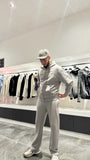 Modèle en mouvement dans un décor urbain, portant l'ensemble zippé pour un layering efficace avec un t-shirt blanc.