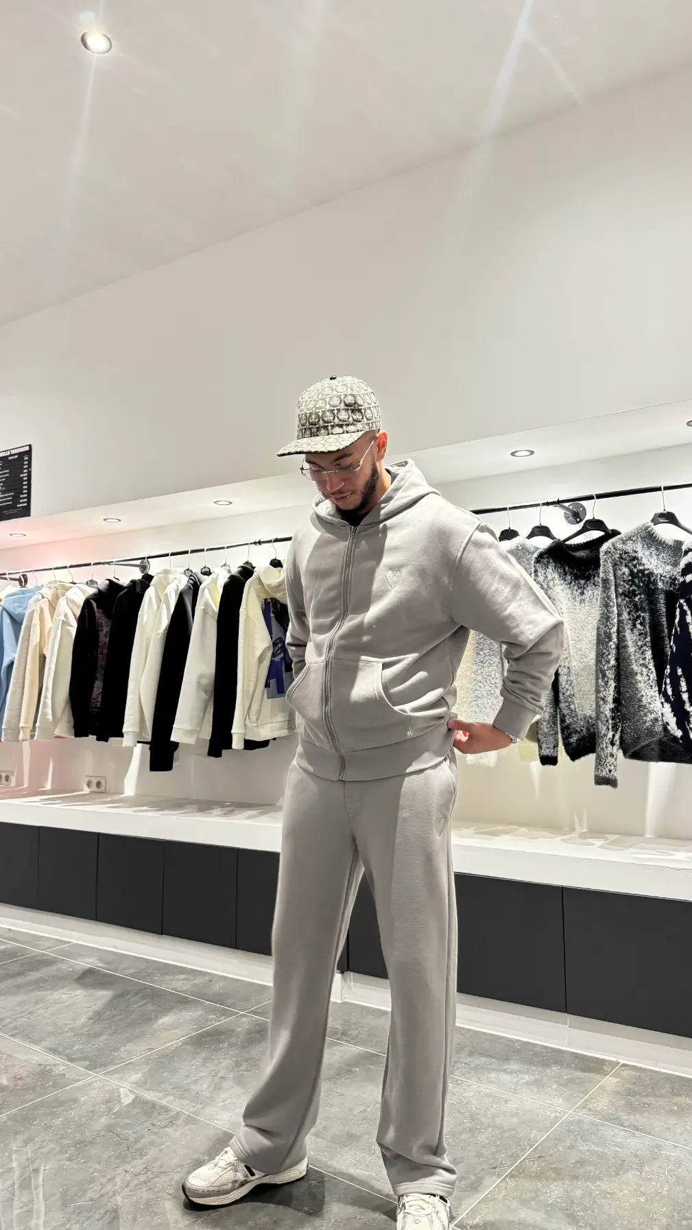 Modèle en mouvement dans un décor urbain, portant l'ensemble zippé pour un layering efficace avec un t-shirt blanc.