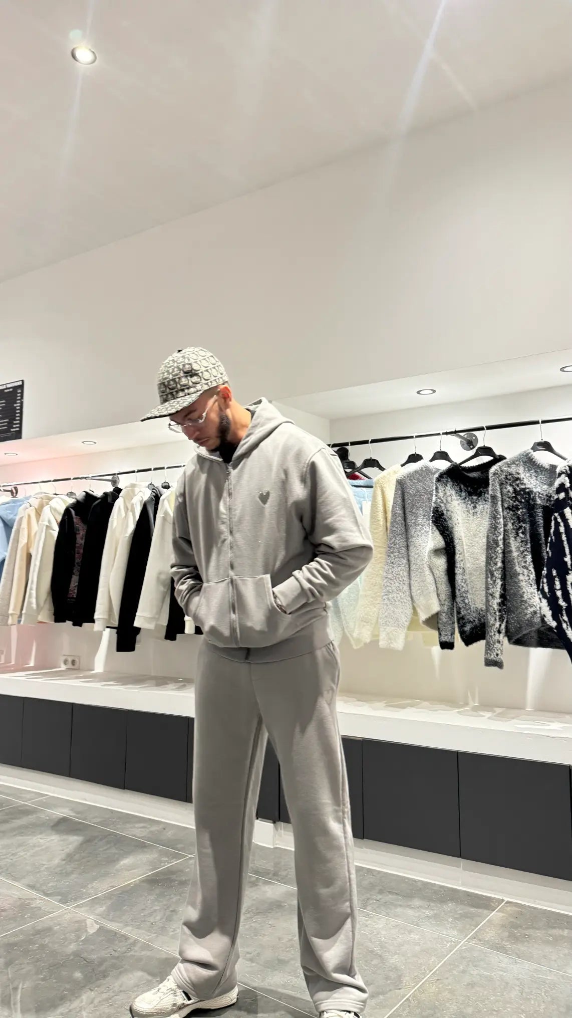 Gros plan sur le détail du logo cœur brodé en relief sur le textile gris chiné, soulignant la qualité des finitions.