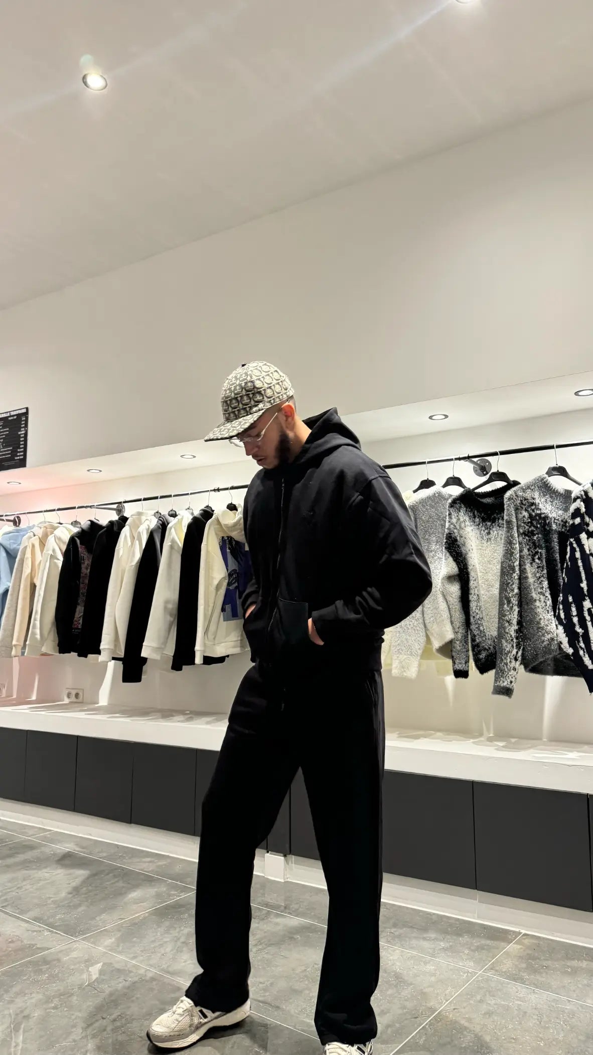 Ensemble noir total avec hoodie zippé et jogging, mettant en avant le contraste subtil du logo cœur brodé.
