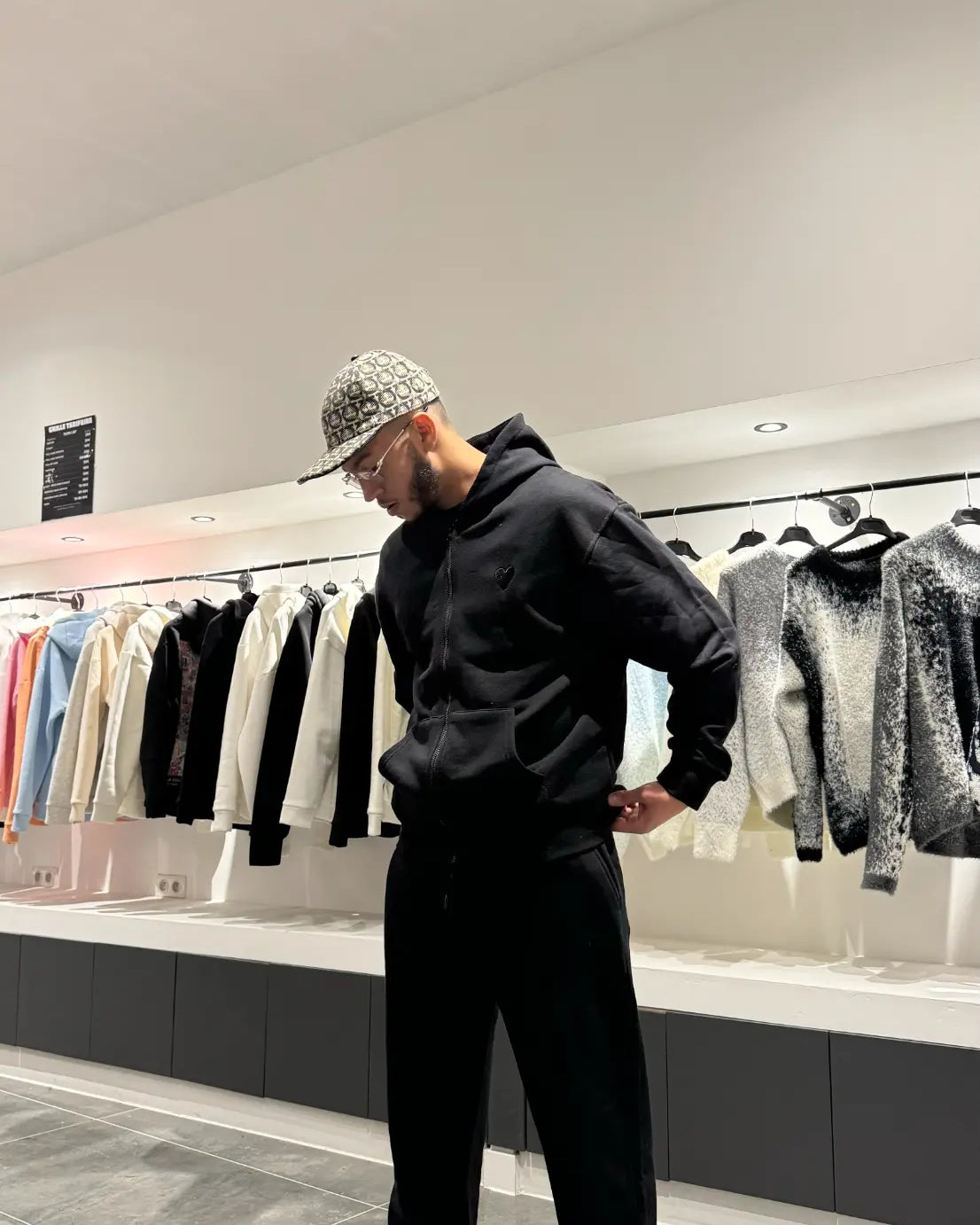 Focus sur la finition impeccable du logo cœur brodé sur le fond noir profond de la veste.