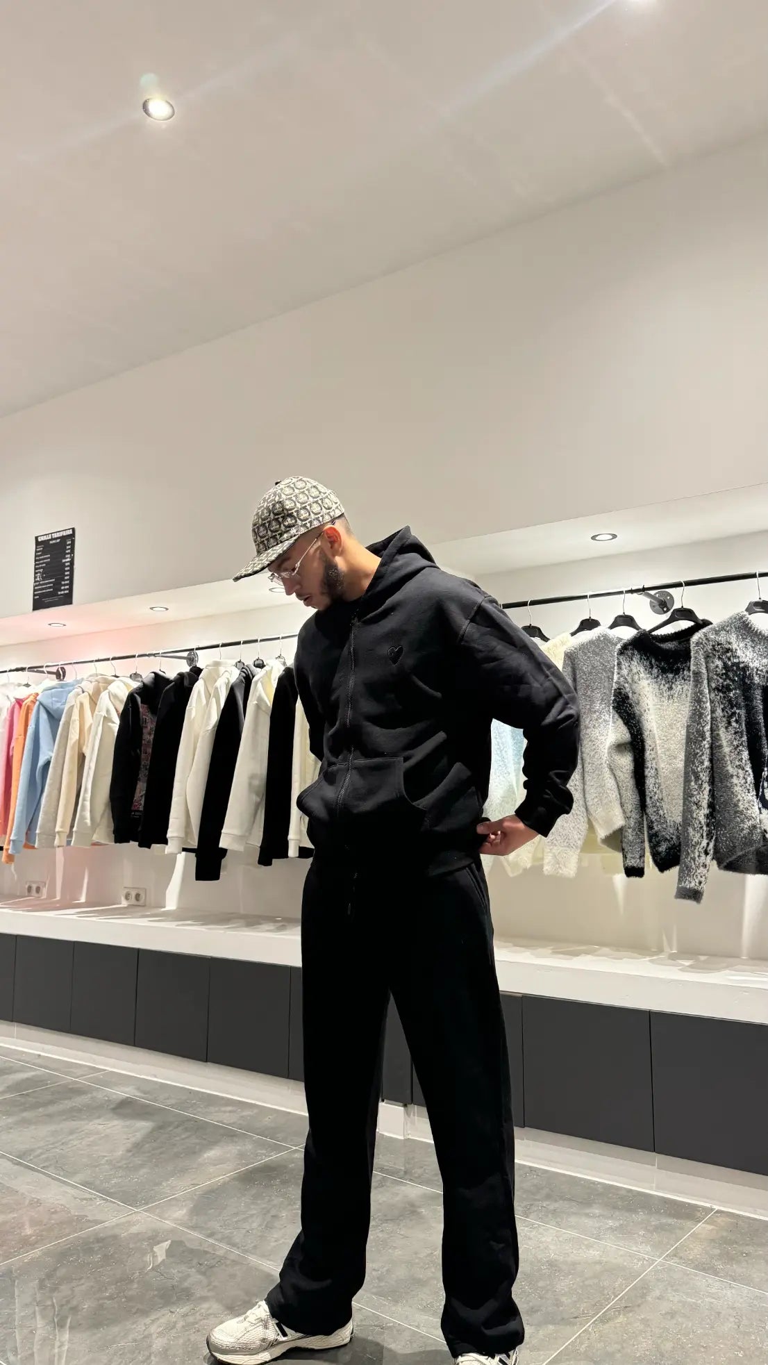 Focus sur la finition impeccable du logo cœur brodé sur le fond noir profond de la veste.