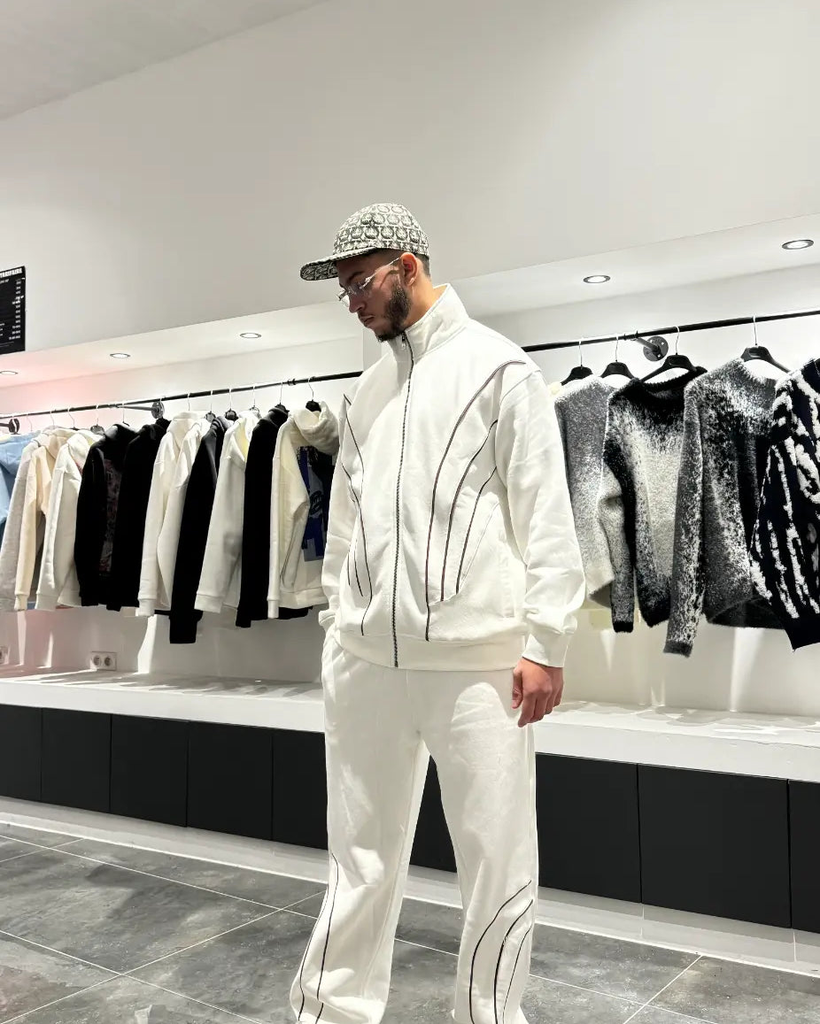 Vue arrière de l'ensemble blanc montrant la coupe oversize-schnitt généreuse et l'absence de détails pour un look minimaliste.