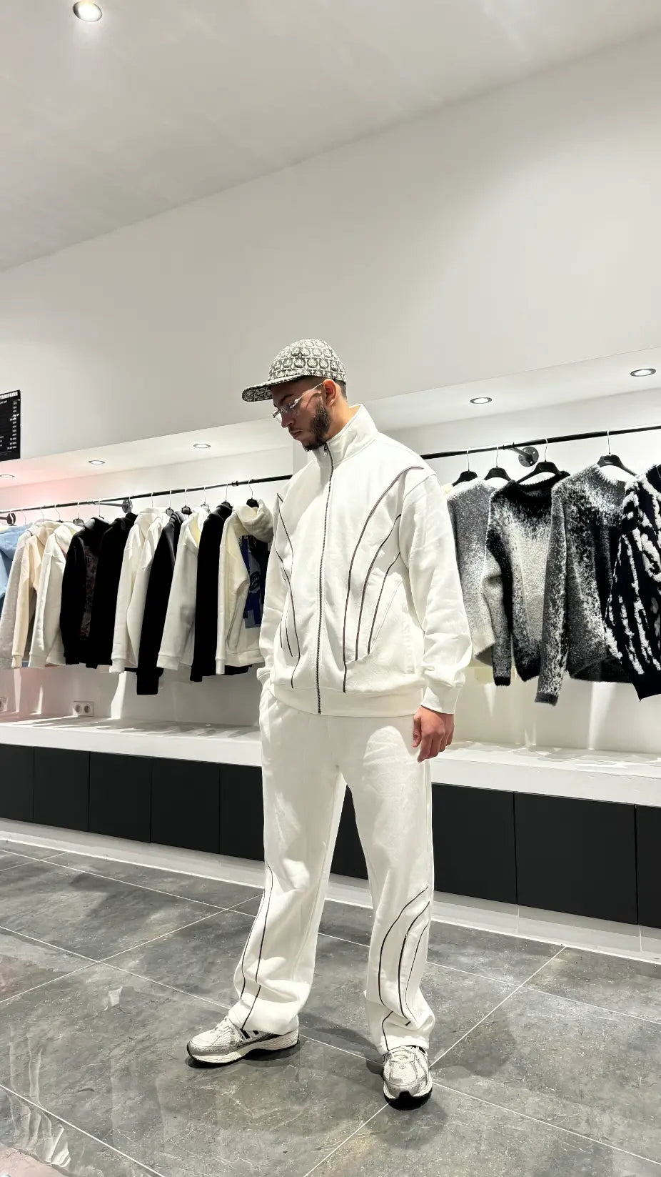 Vue arrière de l'ensemble blanc montrant la coupe oversize-schnitt généreuse et l'absence de détails pour un look minimaliste.