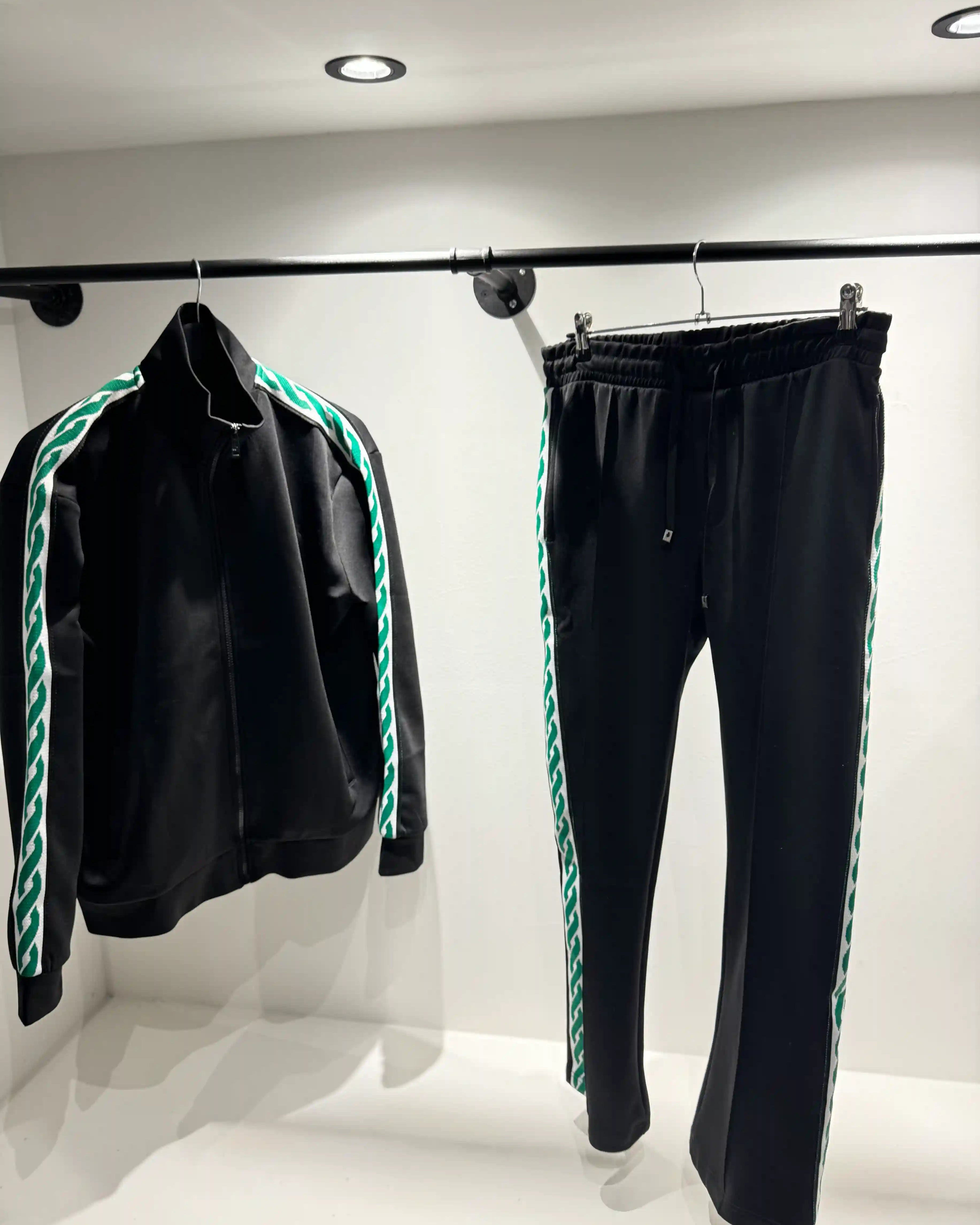 Présentation de l'ensemble noir et vert sur cintre, mettant en valeur le tombé fluide de la matière et les détails latéraux.