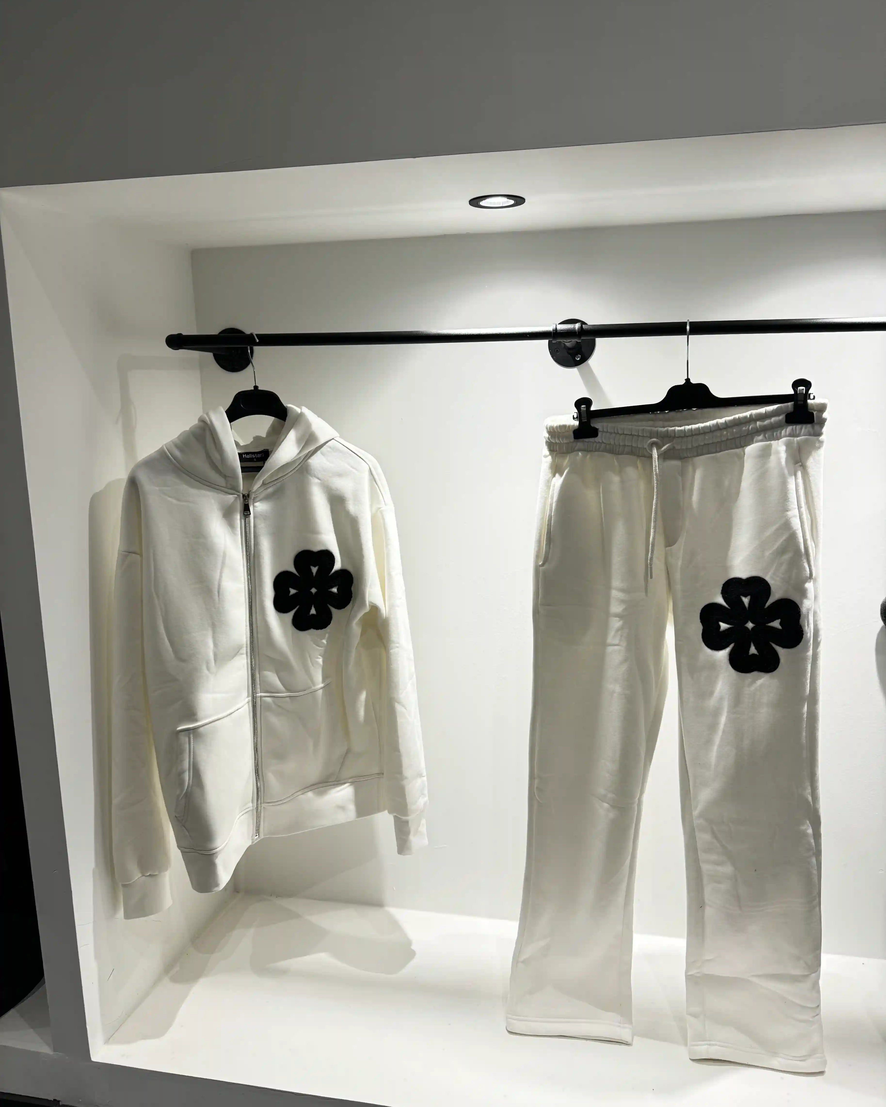 Présentation de l'ensemble blanc sur cintre, illustrant le tombé du gilet et la netteté des détails trèfles.