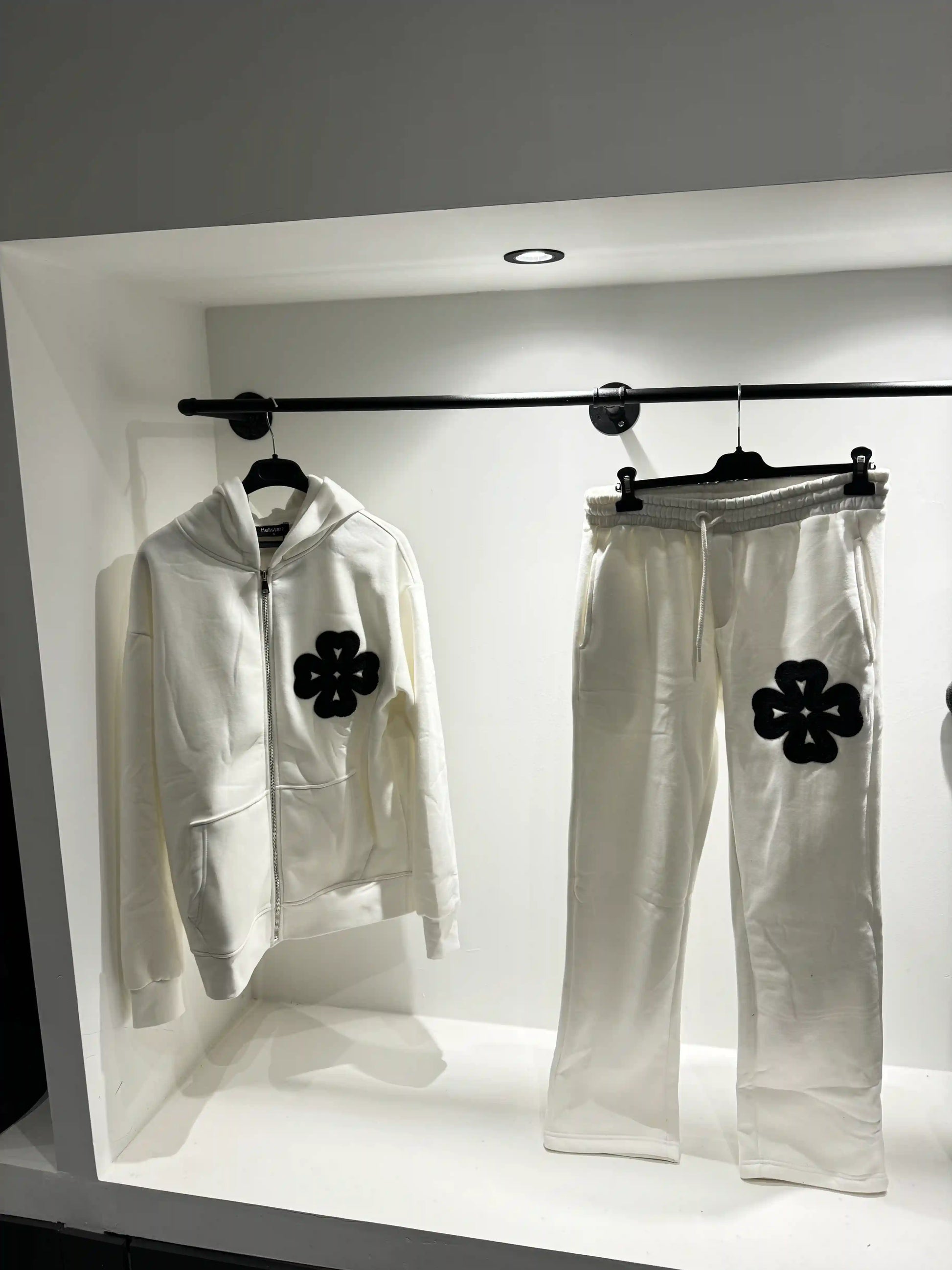 Présentation de l'ensemble blanc sur cintre, illustrant le tombé du gilet et la netteté des détails trèfles.