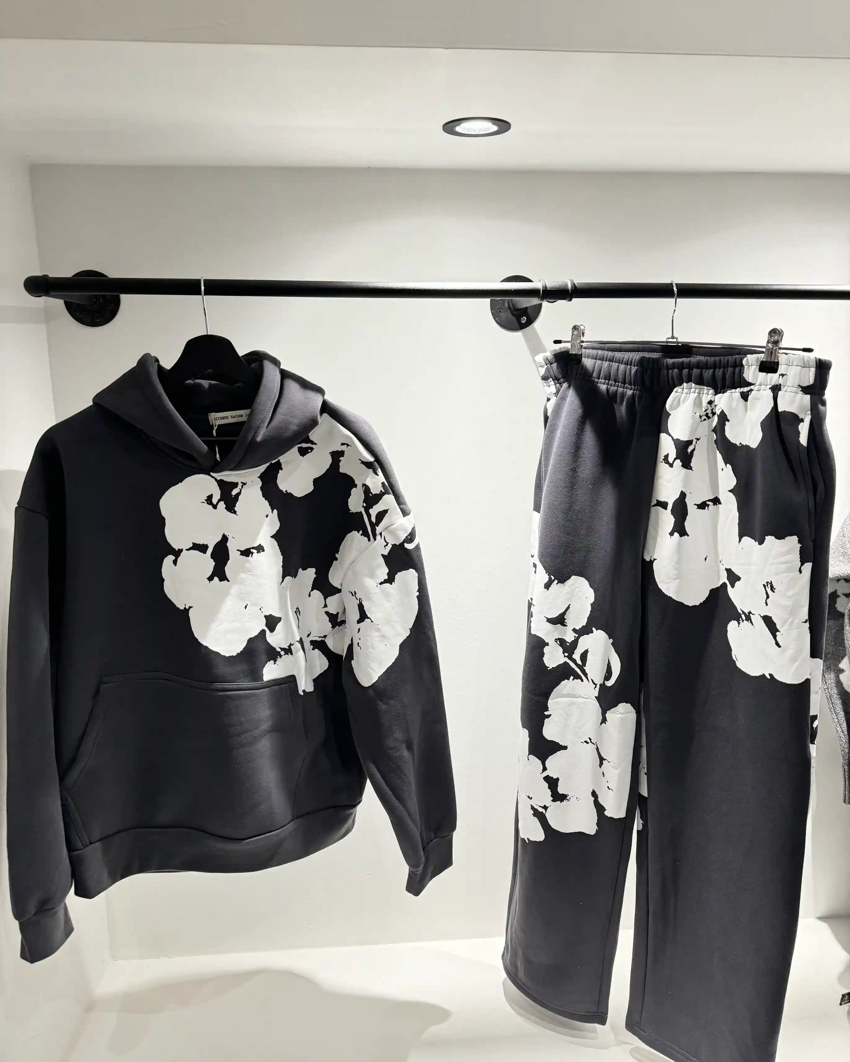 Présentation de l'ensemble gris foncé sur cintre, mettant en avant la clarté du motif sur le textile sombre.