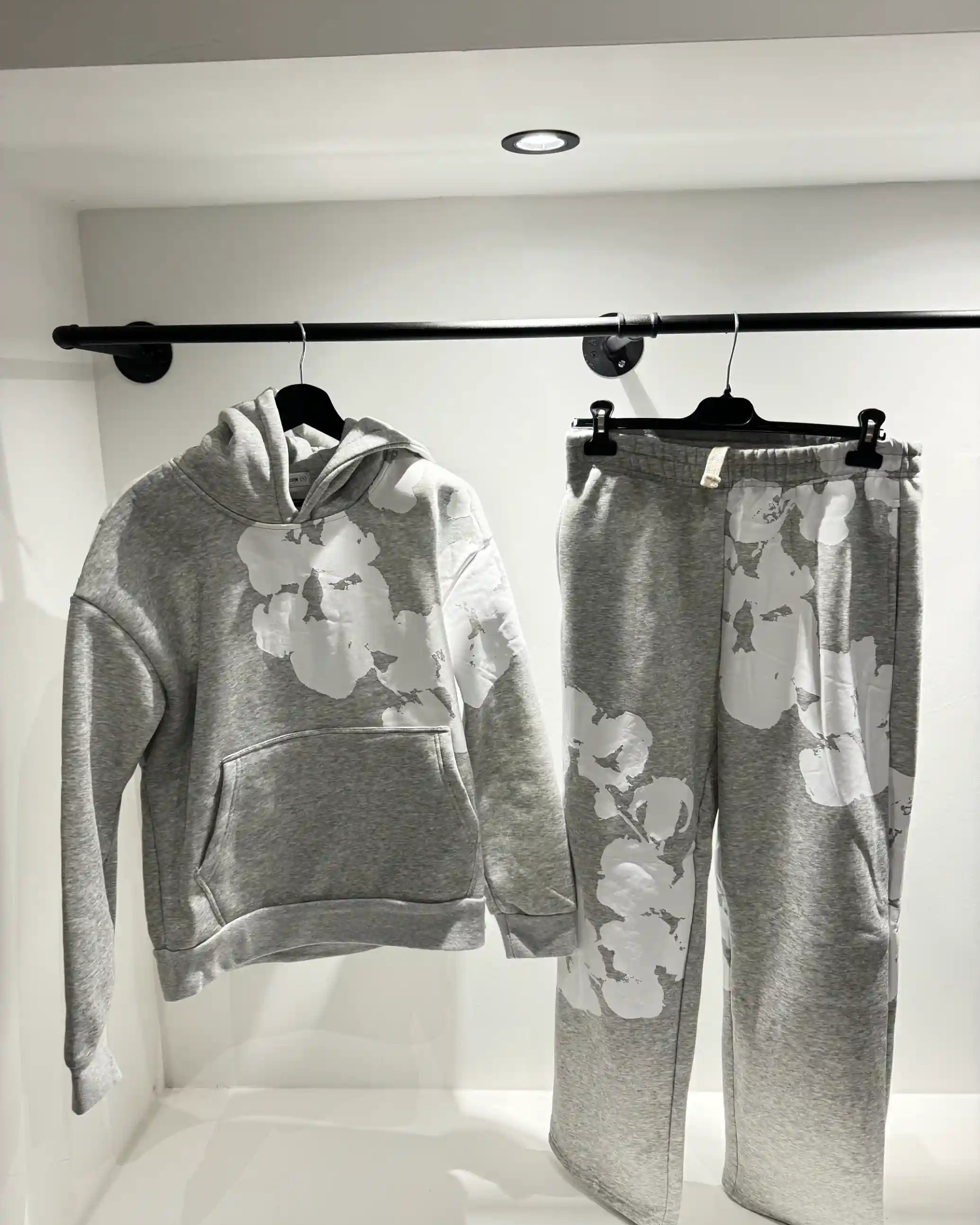 Présentation de l'ensemble gris sur cintre, illustrant le tombé fluide du textile et la disposition du print floral.