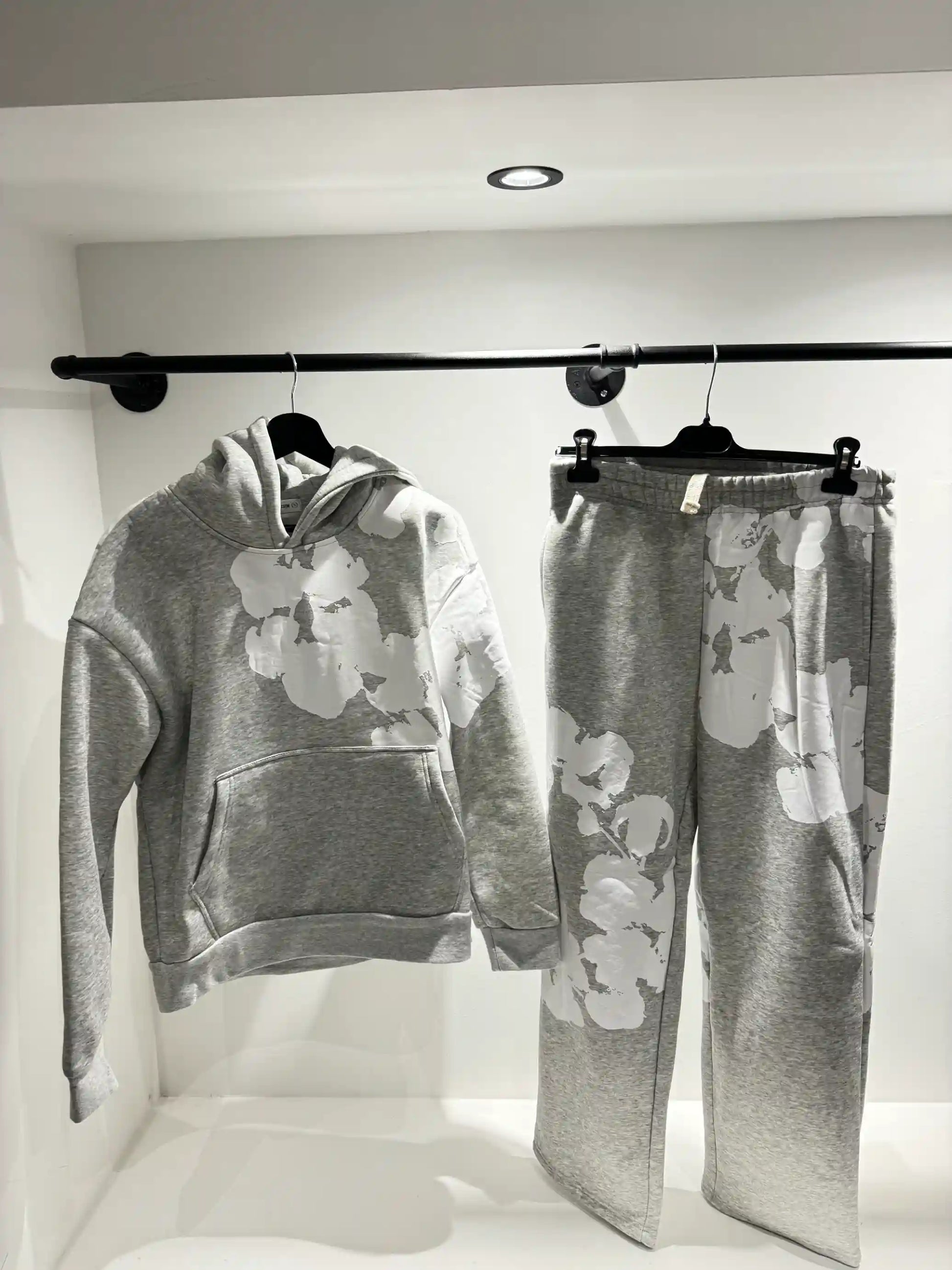 Présentation de l'ensemble gris sur cintre, illustrant le tombé fluide du textile et la disposition du print floral.