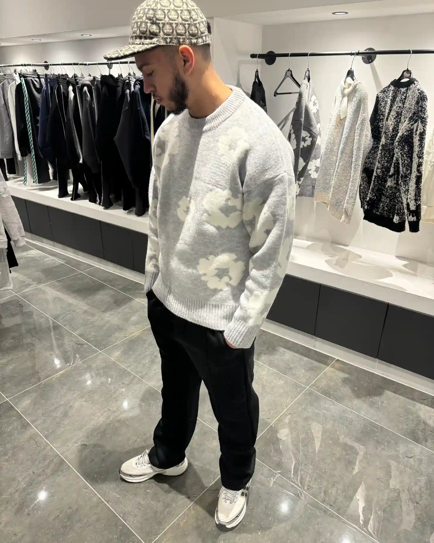 Silhouette complète lumineuse présentant le pull gris et ses fleurs blanches tissées.