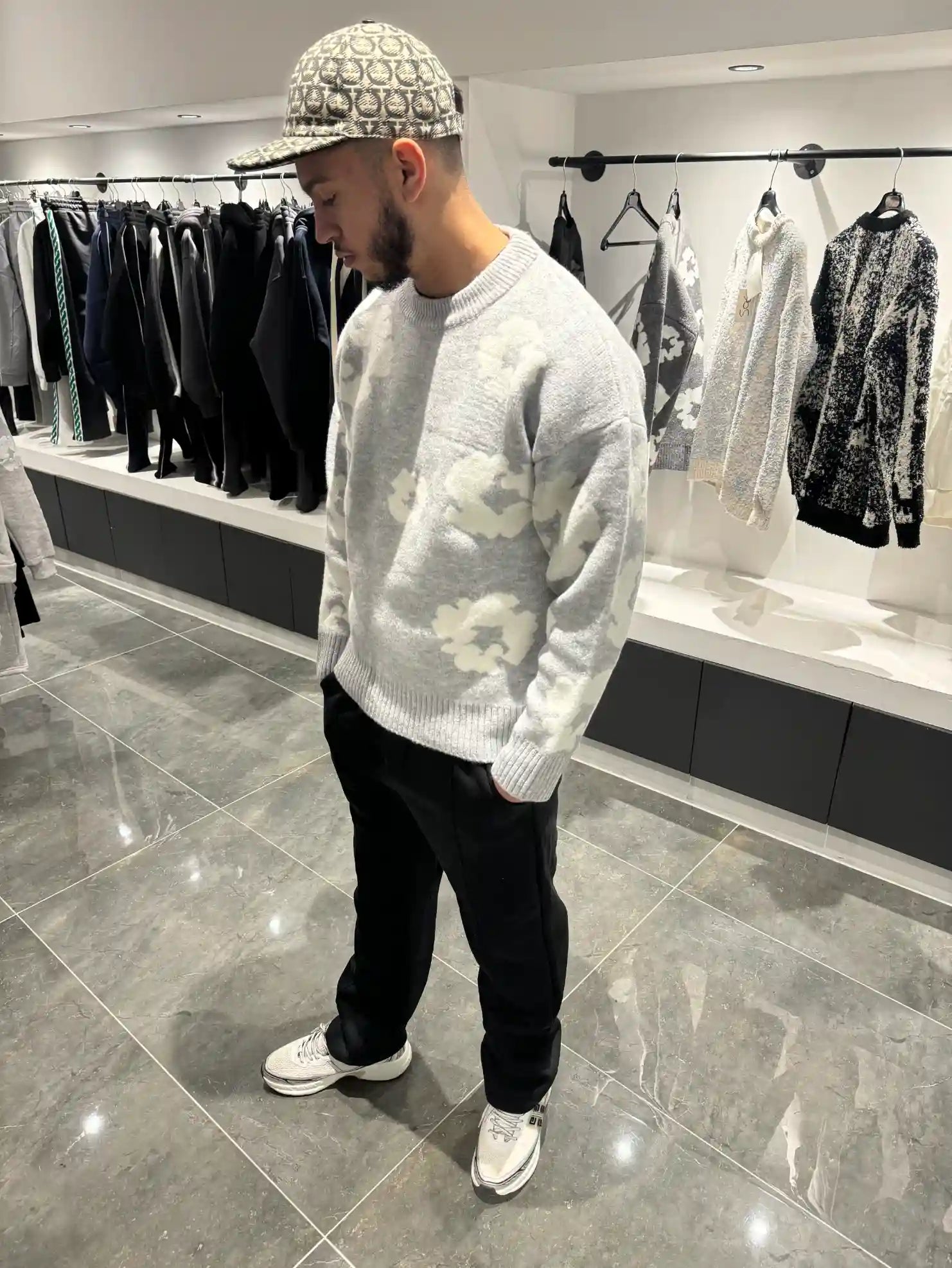 Silhouette complète lumineuse présentant le pull gris et ses fleurs blanches tissées.
