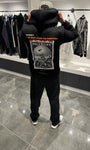 Silhouette complète de dos présentant le hoodie noir oversize avec la grande photo de la Palestine et l'écriture arabe.
